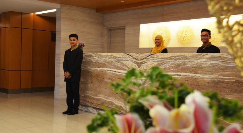 a man standing next to a woman in front of a wall, V8 Hotel in Johor Bahru