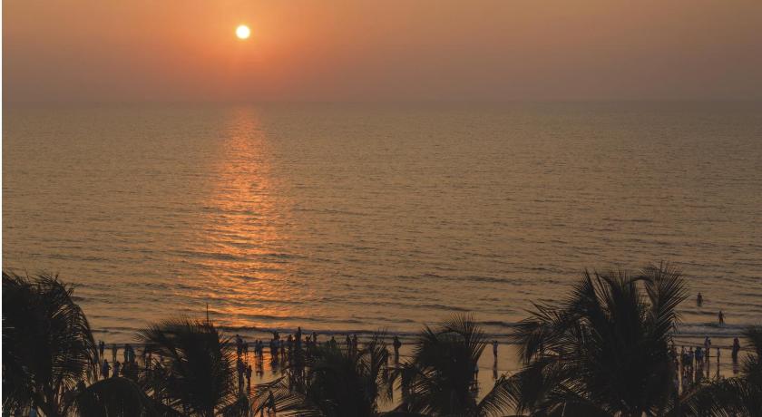 a sunset view of a beach with palm trees, Ramada Plaza by Wyndham Palm Grove in Mumbai