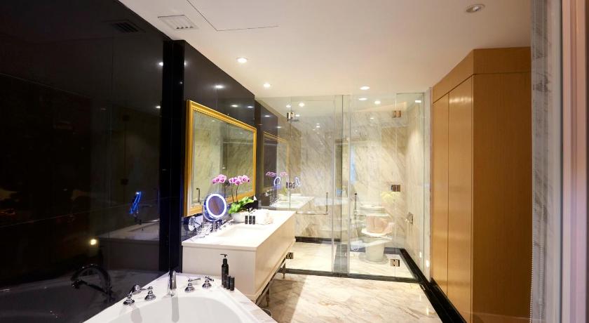 a bathroom with a tub, sink, and mirror, Kingwood Boutique Hotel in Miri