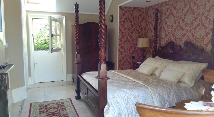 a bedroom with a large bed and a large window, Riverside Lodge in Carlingford