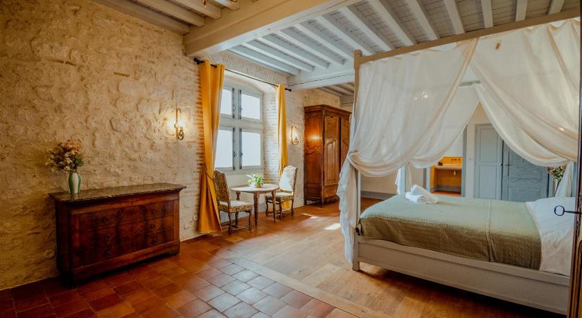 Charming empty French hotel room with four-poster bed and traditional architecture