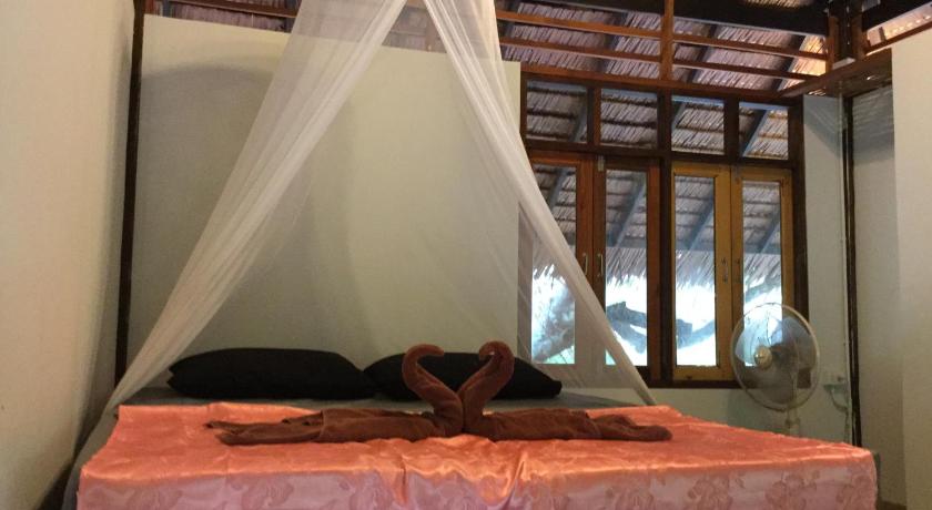 a person laying on a bed in a room, Cashew Nut Bungalow, Ko Mook in Trang