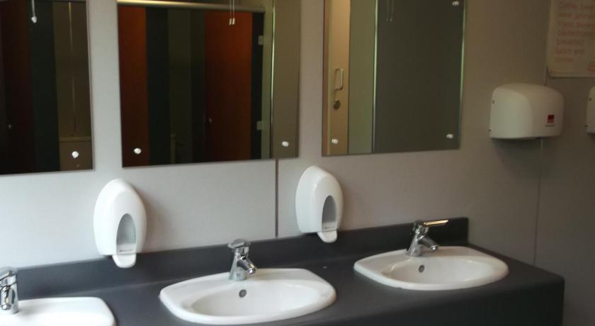 a bathroom with two sinks and two mirrors, Crianlarich Youth Hostel in Crianlarich