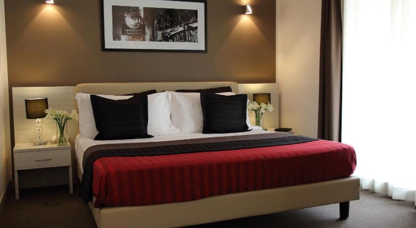 a bed with a white bedspread and pillows in a room, Stelle Hotel the Businest in Naples