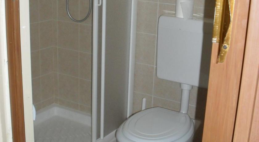 a white toilet sitting next to a shower in a bathroom, Al Caminetto in Aosta