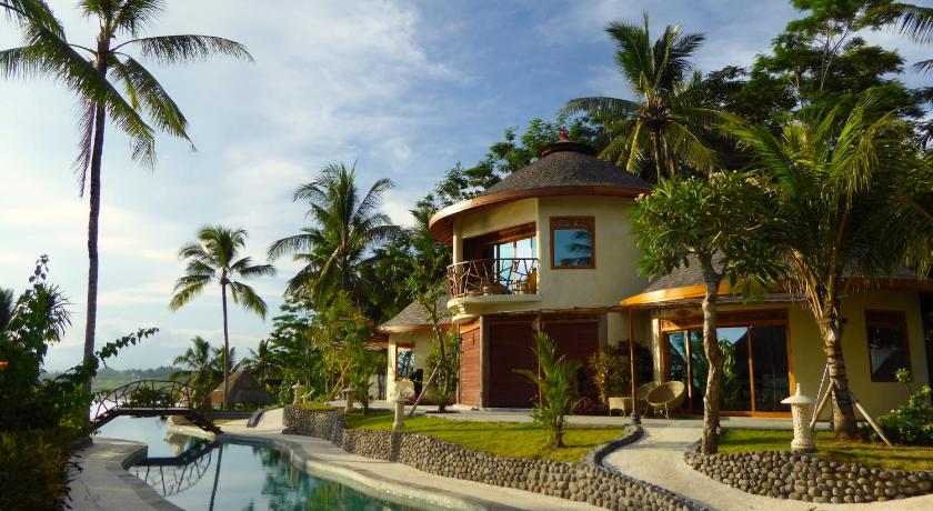 a large white house with a balcony overlooking the ocean, Puri Dajuma Beach Eco Resort & Spa in Bali
