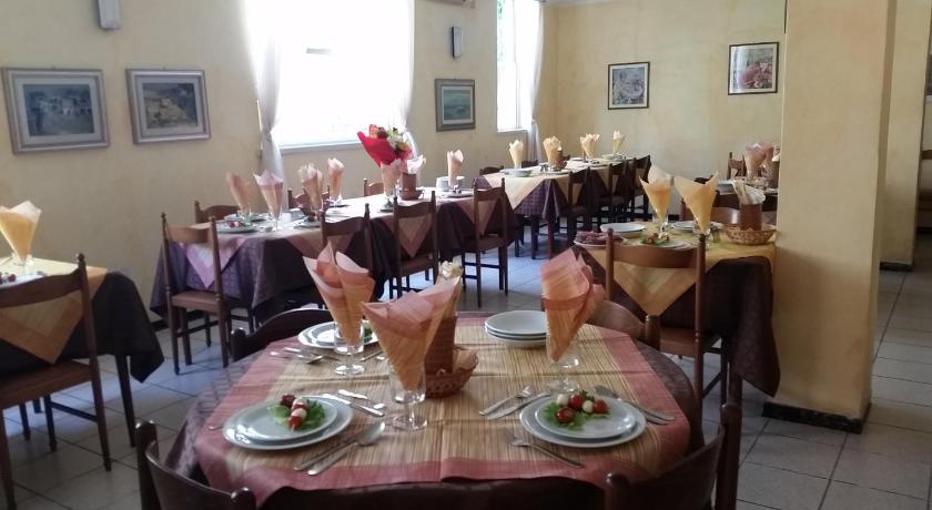 a dining room table with chairs and plates of food, Hotel Eleonora in Rimini
