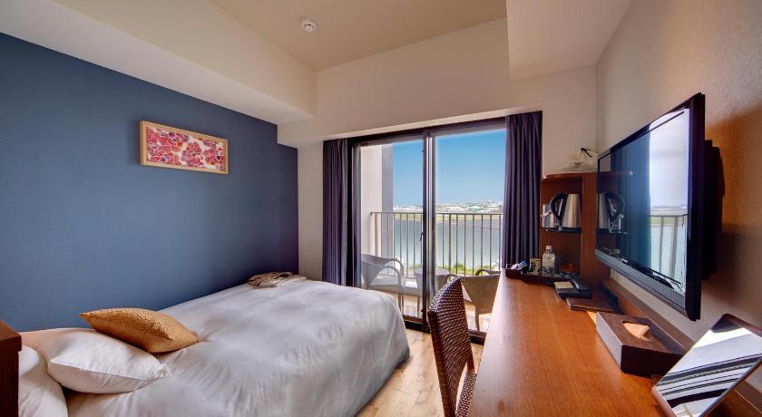 a hotel room with a bed, television and a desk, Ryukyu Onsen Senagajima Hotel in Okinawa Main island