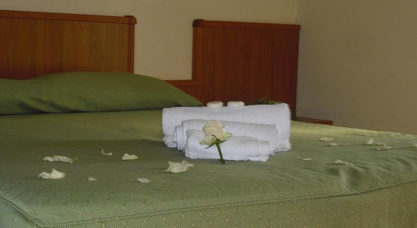 a bed with a white blanket and pillows on top of it, La Collinetta in Montazzoli