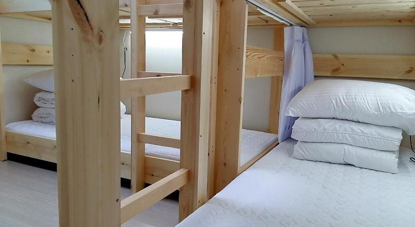 a bedroom with a bed and a window, Baebae guesthouse in Jeju