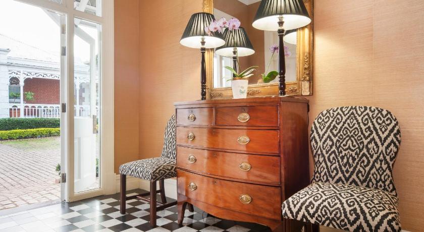 a living room with a dresser and a chair, Quarters Hotel in Durban