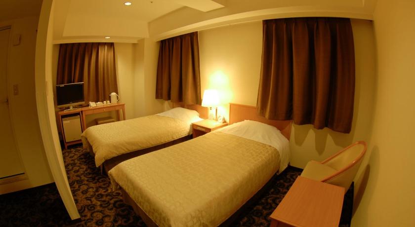 a hotel room with two beds and two lamps, Nansei Kanko Hotel in Okinawa Main island