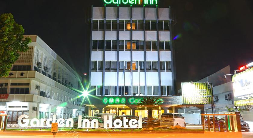 a large building with a neon sign on the side of it, Garden Inn Hotel in Penang