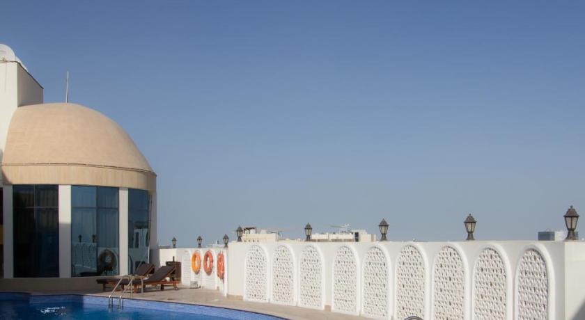 a swimming pool with blue walls and a blue sky, Horizon Manor Hotel in Doha