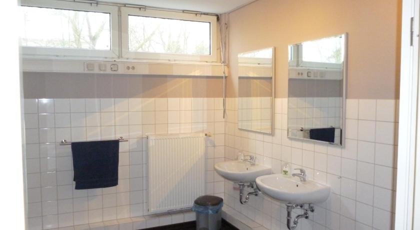 a bathroom with a toilet, sink and mirror, Bergedorf Haus 9 in Hamburg