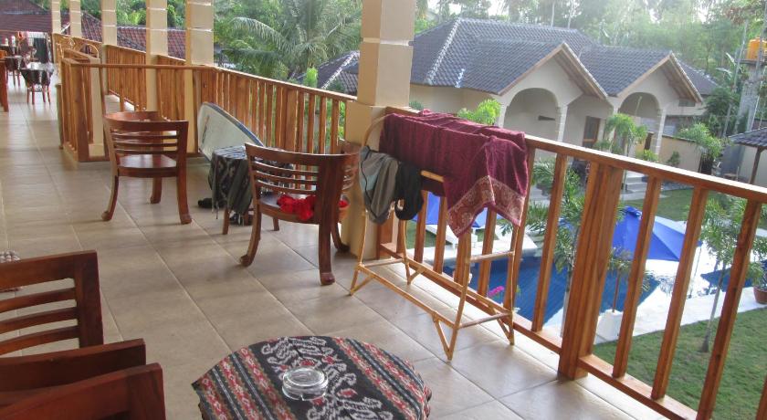 a patio area with chairs, tables, and umbrellas, Yuli's Homestay in Lombok