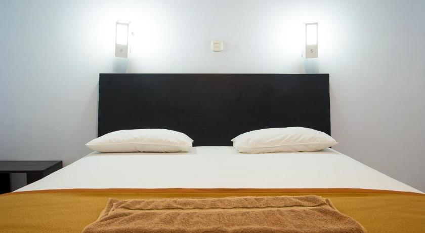 a bed with two pillows on top of it, Hotel Ledetadu in Kupang