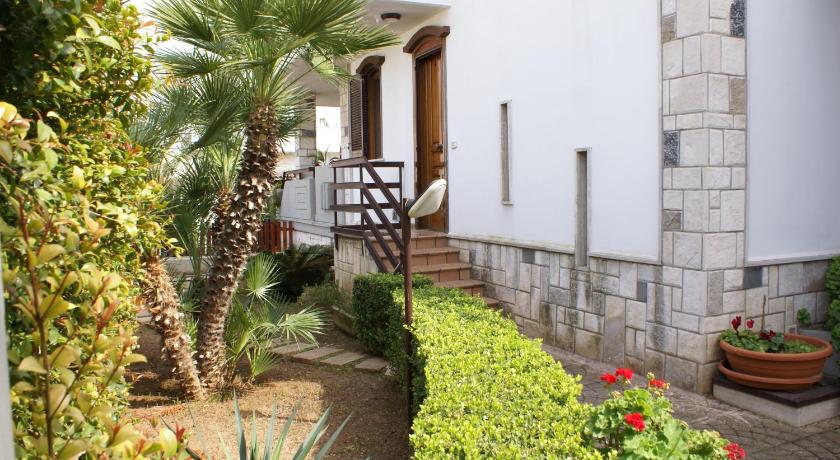 a garden area with a couple of steps leading to a building, B&B Del Maresciallo in Leporano Marina