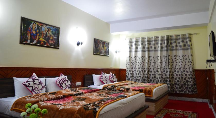 a hotel room with two beds and a table, Hotel Golden Sunrise & Spa in Pelling