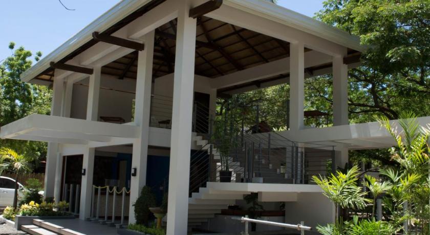 a large wooden bench in front of a large building, Karancho Beach House in Cebu