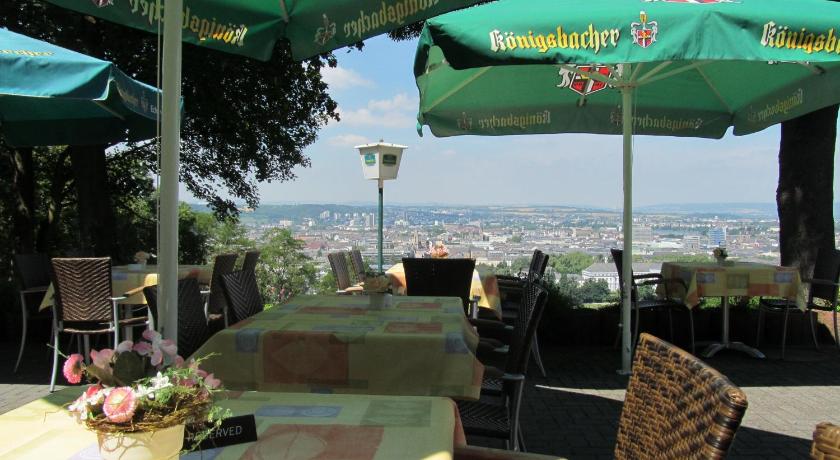 a patio area with tables, chairs and umbrellas, Hotel Rheinkrone in Koblenz
