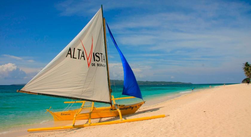 a sailboat sitting on top of a sandy beach, Alta Vista de Boracay Hotel in Boracay Island