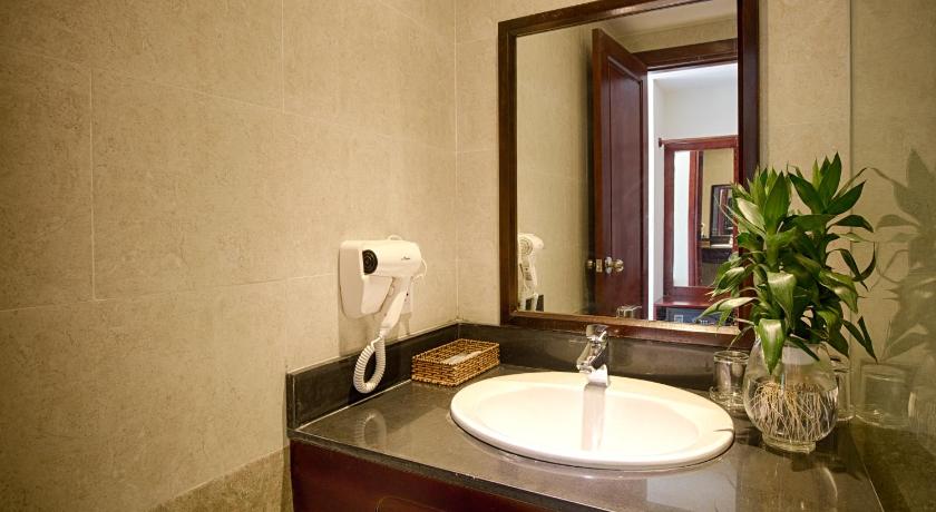 a white toilet sitting in a bathroom next to a mirror, Hoi An Green Apple Hotel in Hoi An