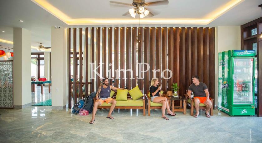 three women sitting on a wooden bench in a living room, Hoi An Green Apple Hotel in Hoi An