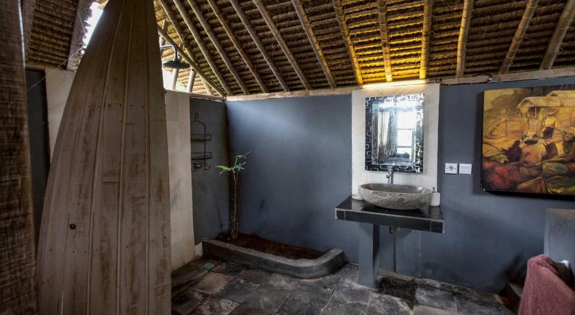 a room with a toilet and a painting on the wall, Gipsy Beach Bungalows in Lombok