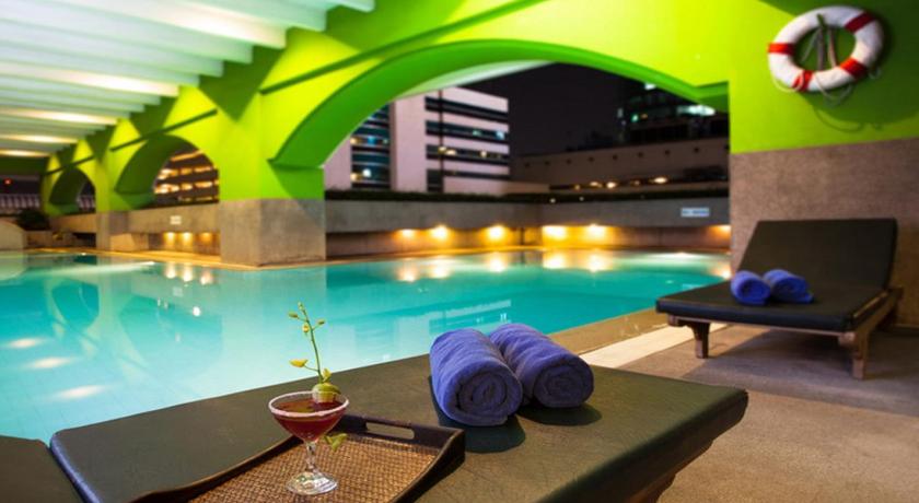 a lounge area with chairs, a pool and a pool table, Arnoma Grand in Bangkok