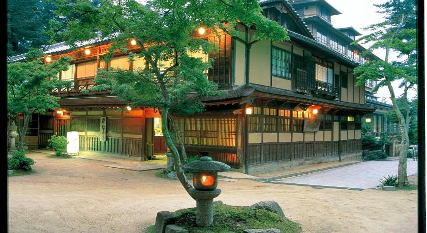 a tree in front of a building with a large window, Iwaso Ryokan in Hiroshima