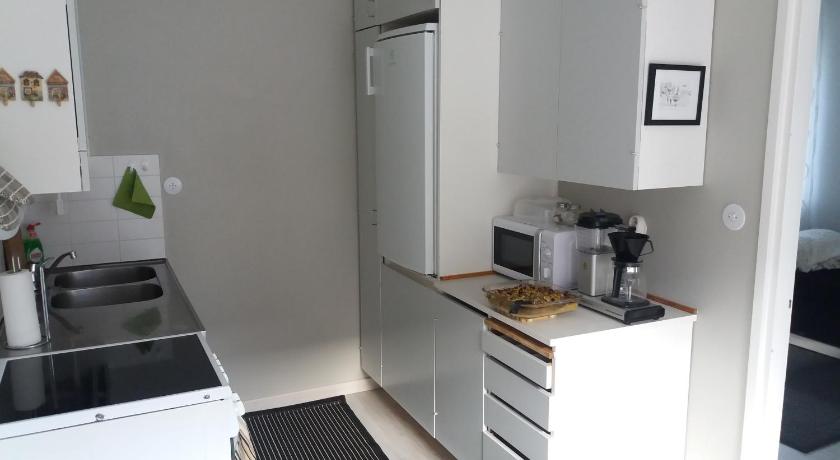 a kitchen with white cabinets and white appliances, Apartment Vuorikatu 35 in Kuopio