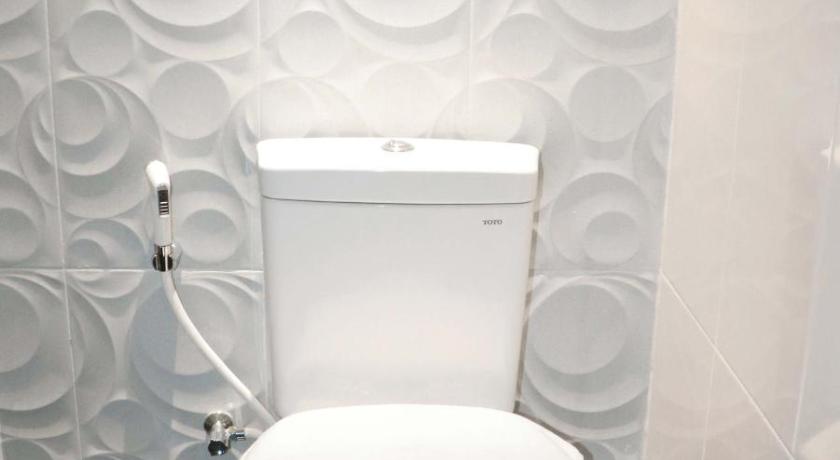a white toilet sitting next to a white wall, Luminor Hotel Pecenongan in Jakarta