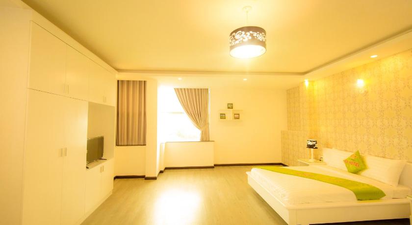 a bedroom with a white bed and white walls, New Hotel in Bình Dương