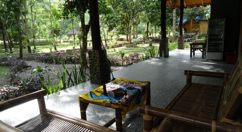 a wooden bench sitting in the middle of a park, Batu Kapal Guest House in Timbang Lawan