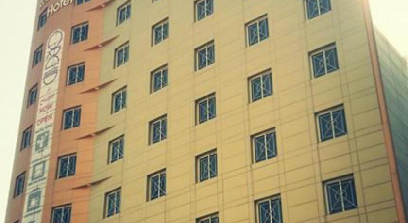 a large building with a clock on the front of it, Rose Garden Hotel in Riyadh