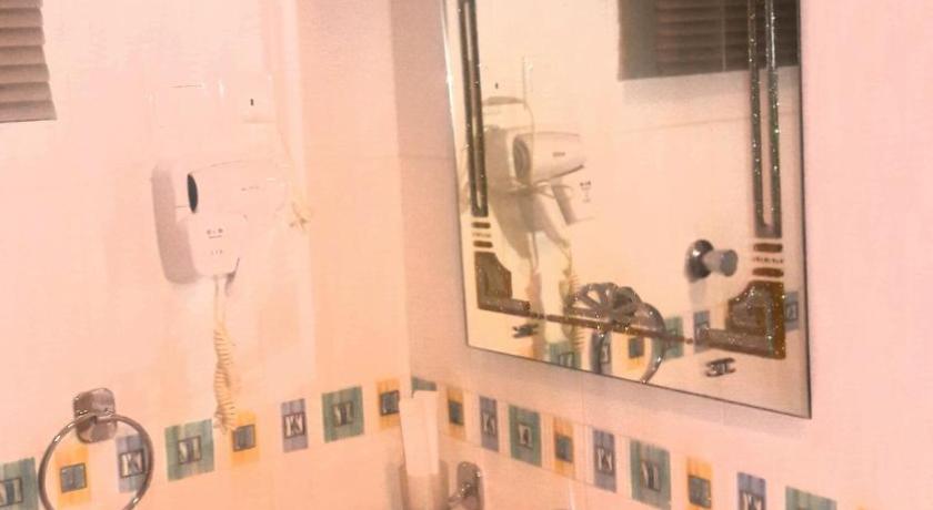a white sink sitting under a mirror in a bathroom, Rose Garden Hotel in Riyadh