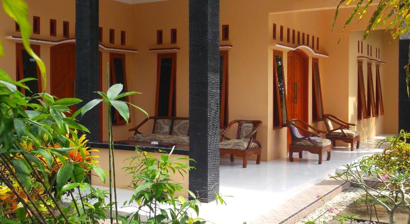 a patio area with chairs, tables, and umbrellas, Ragha Homestay in Pangandaran