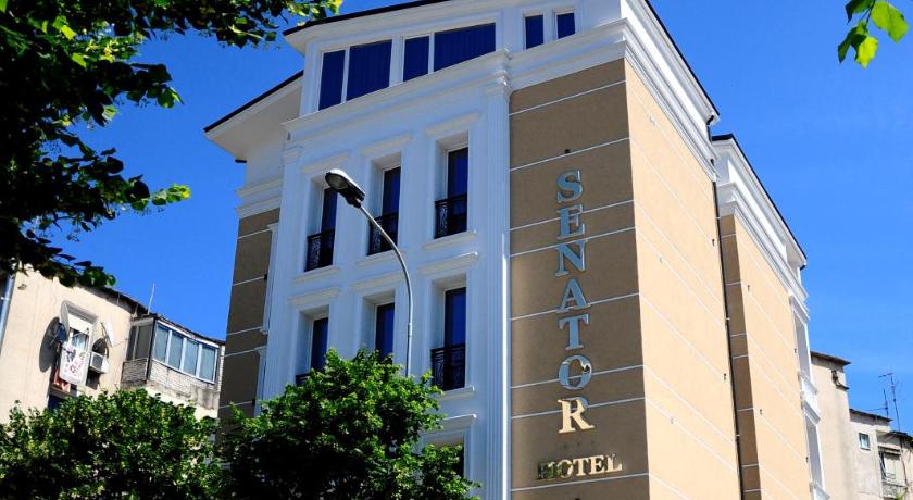 a large building with a clock on the front of it, HOTEL SENATOR TIRANE in Tirana