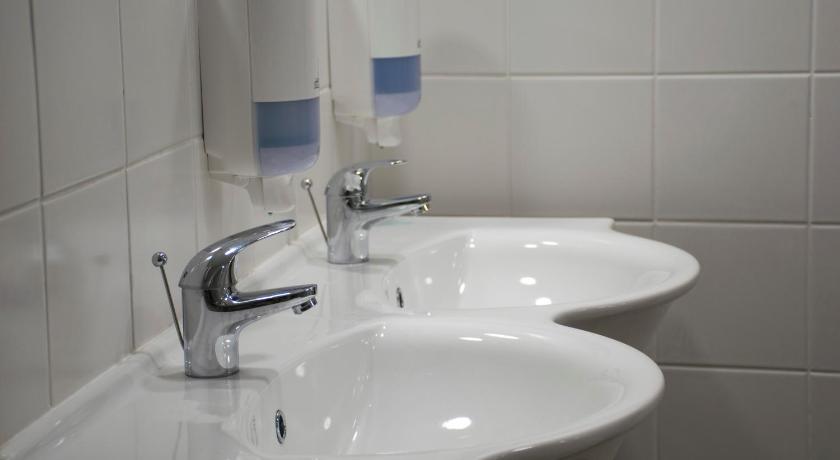 a white sink sitting under a mirror in a bathroom, C - Punkt Hostel in Ljubljana