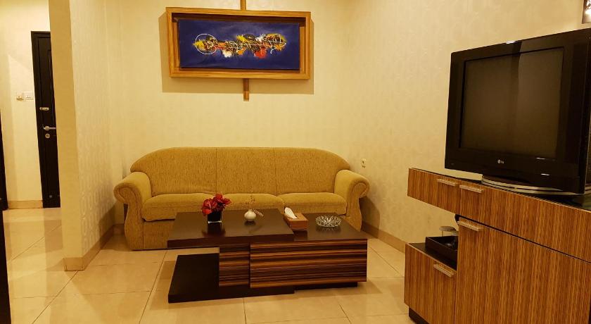 a living room filled with furniture and a tv, Crown Hotel in Tanjung Selor
