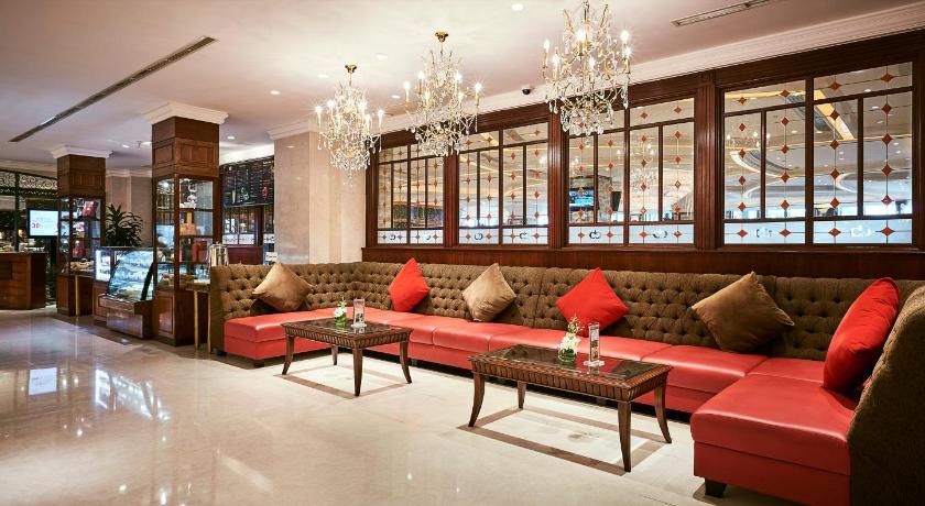 a living room filled with furniture and a red couch, Windsor Plaza Hotel in Ho Chi Minh City