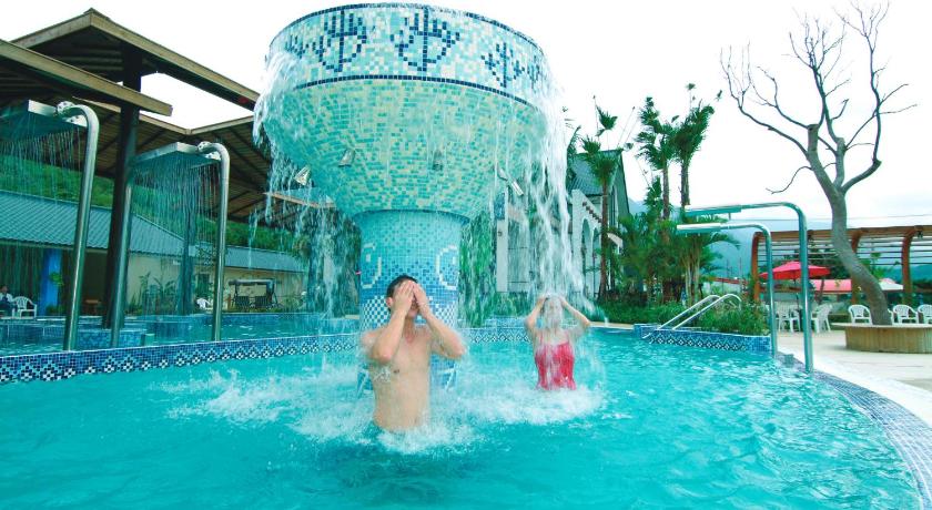 a woman is swimming in a pool in a swimming pool, Fennel Hot Spring Resort in Kenting