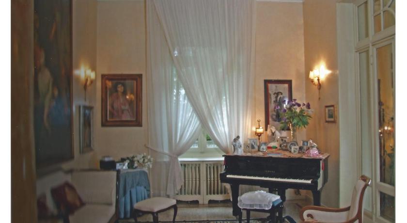 a living room filled with furniture and a piano, Villa V in Brescia