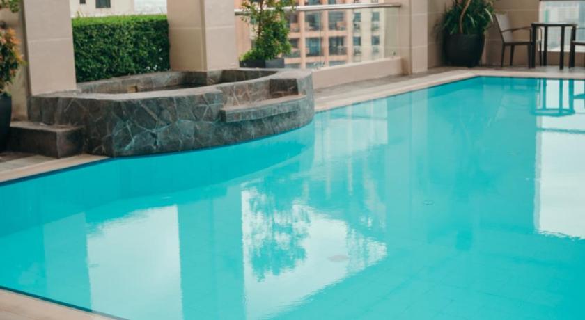 a blue and white swimming pool with a blue chair, City Garden Hotel Makati in Manila