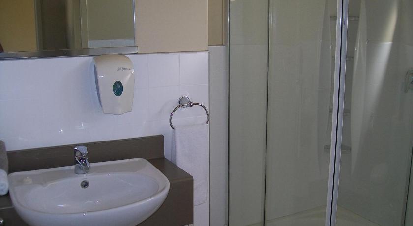 a bathroom with a sink and a shower, Sierra Motel & Apartments in Omarama