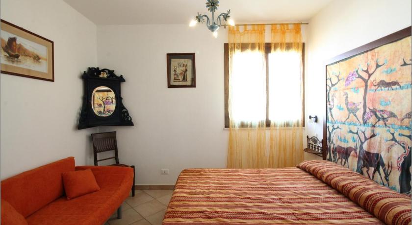 a room with a bed, a desk, and a painting on the wall, Senia in San Vito Lo Capo