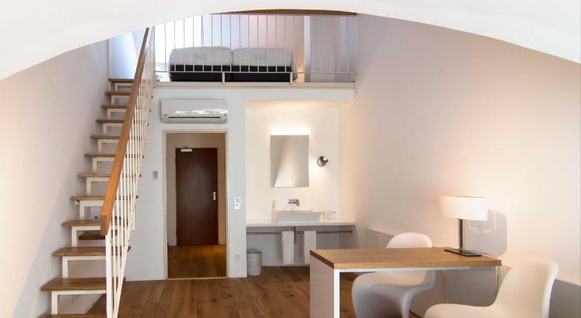 a room with a table, chairs, and a staircase, Vi Vadi Hotel Downtown Munich in Munich