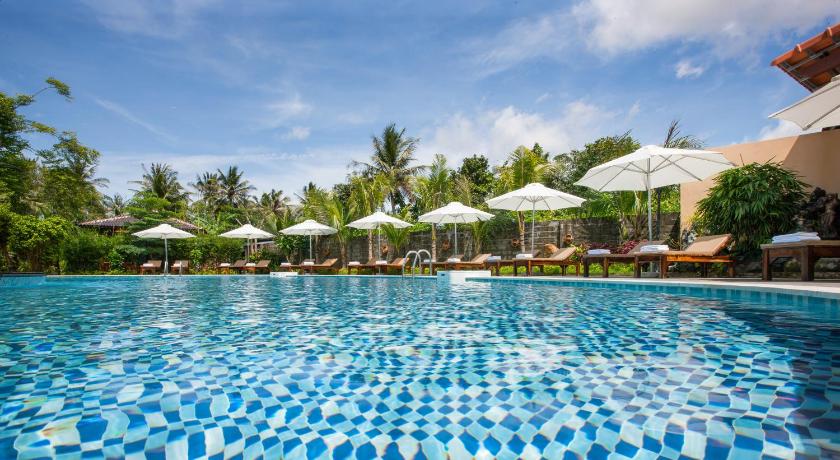 a pool with blue umbrellas in the middle of it, Elwood Premier Resort Phu Quoc in Phu Quoc Island