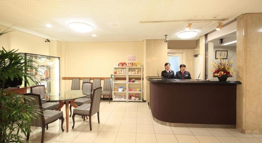 a room with a table, chairs, and a clock on the wall, Chofu Urban Hotel in Chofu